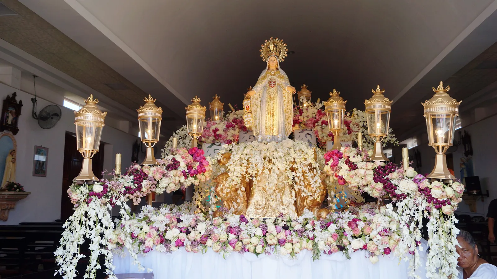 Flower-covered altar with the statue of La Merced, patron of Guararé